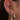 Close-up of an ear with multiple silver earrings