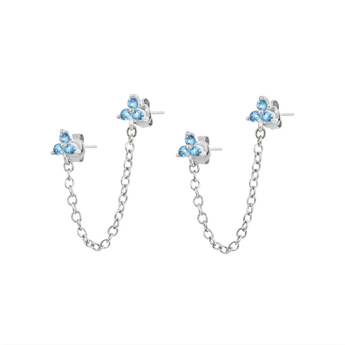 Silver chain stud earrings with blue crystals placed on a white background