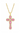Gold cross pendant with pink gemstones on a white background