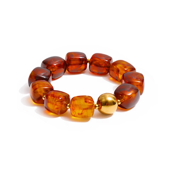 Bracelet with amber beads and a gold accent on a white background