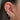 Close-up of an ear with multiple gold and diamond earrings.